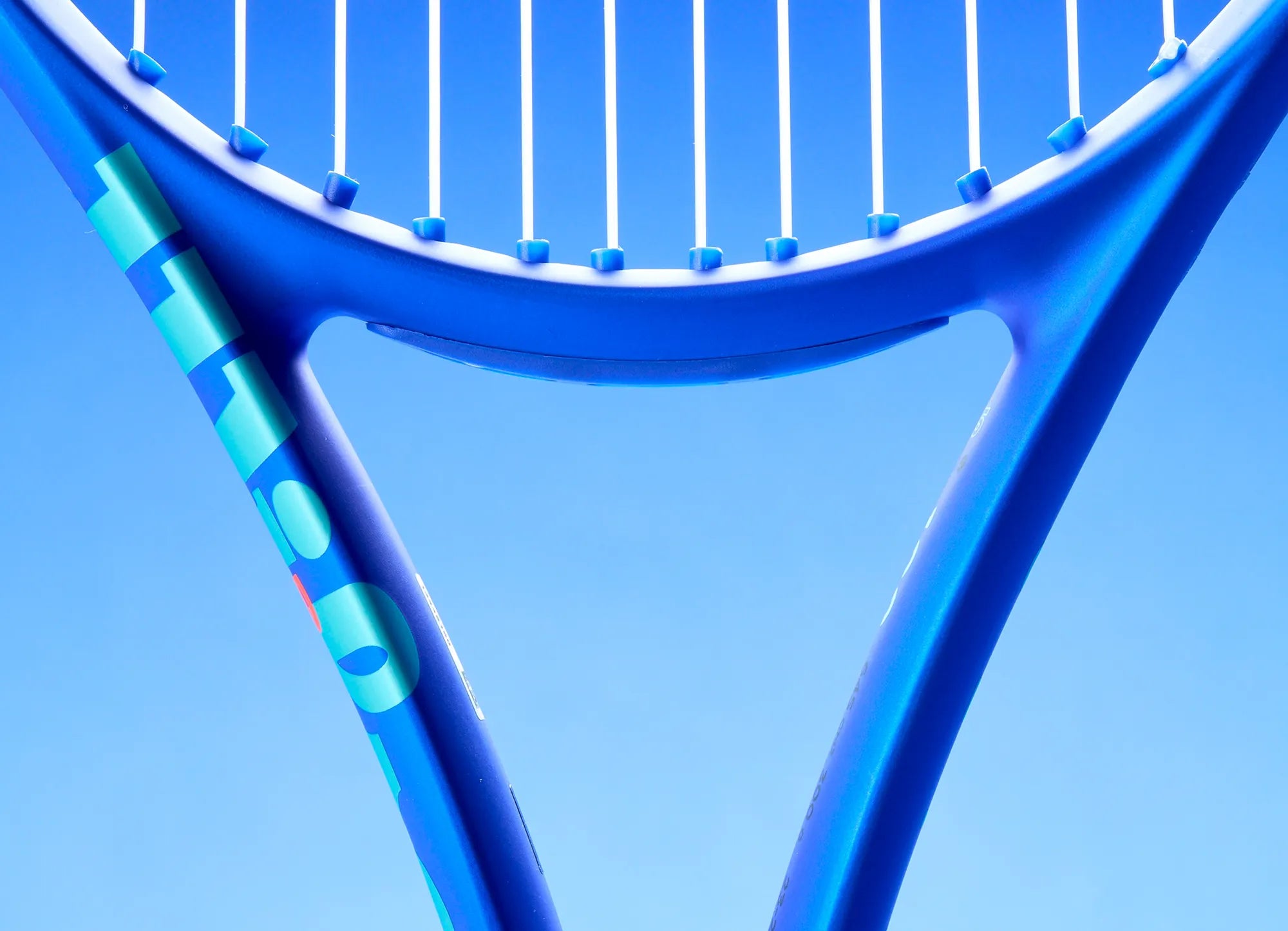 Close-up of a blue tennis racket against a clear blue background