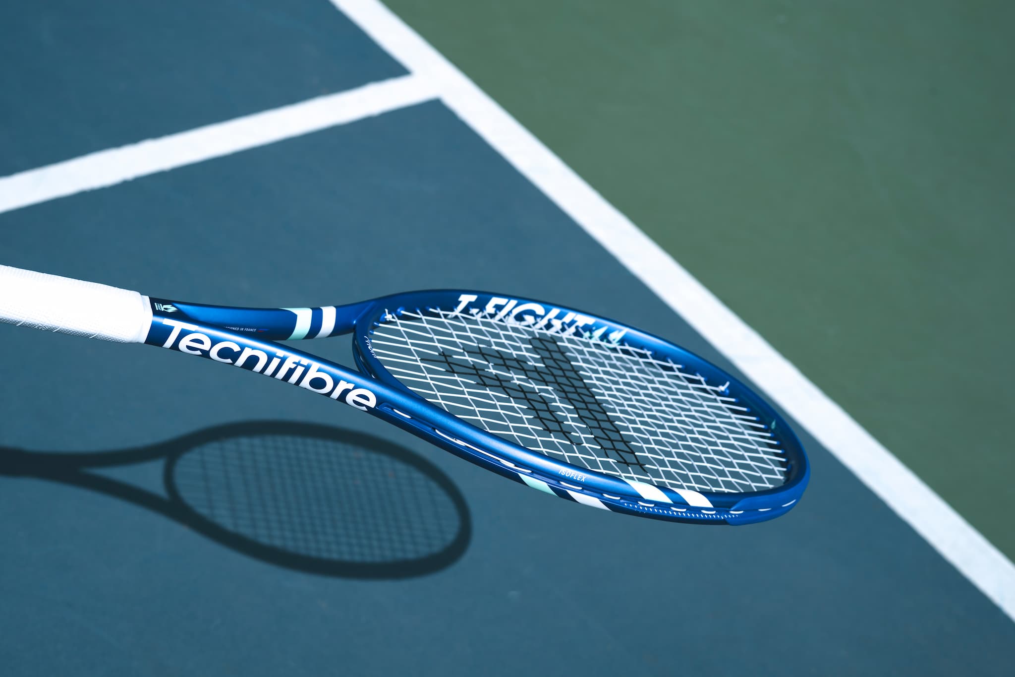 Blue and white tennis racket on a tennis court