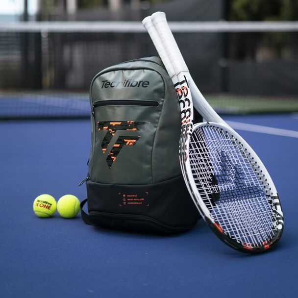 Tennis racket, backpack, and balls on a tennis court
