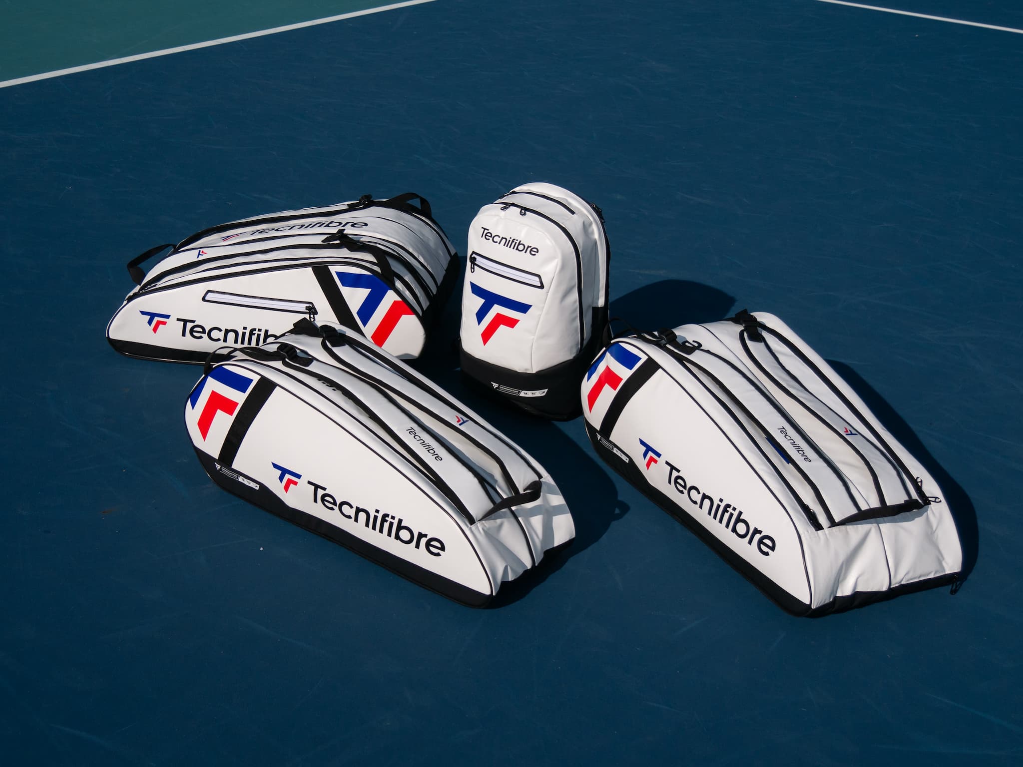 Four Tecnifibre tennis bag on a blue tennis court